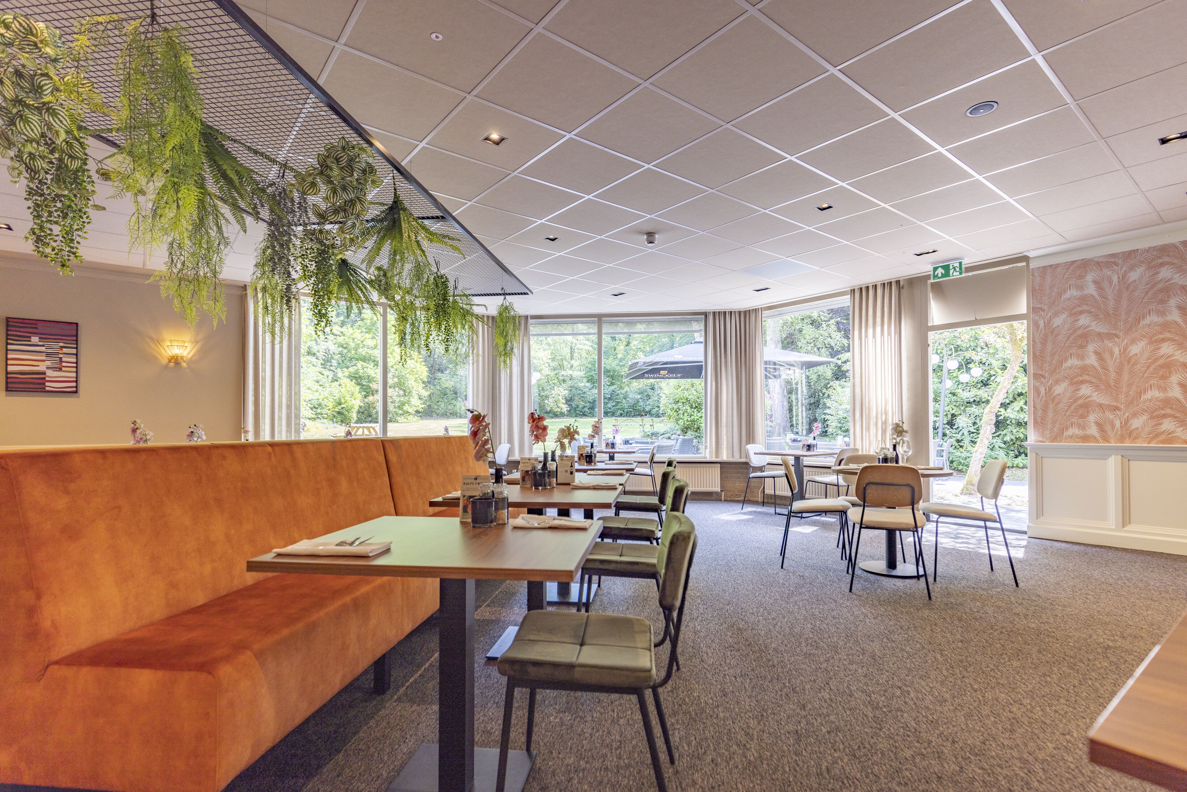Ein modernes Restaurant mit einer langen Holzbänke, mehreren Tischen und Stühlen.