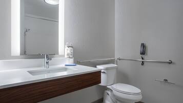 Un bagno moderno con un lavandino bianco, uno specchio, un water e una doccia.