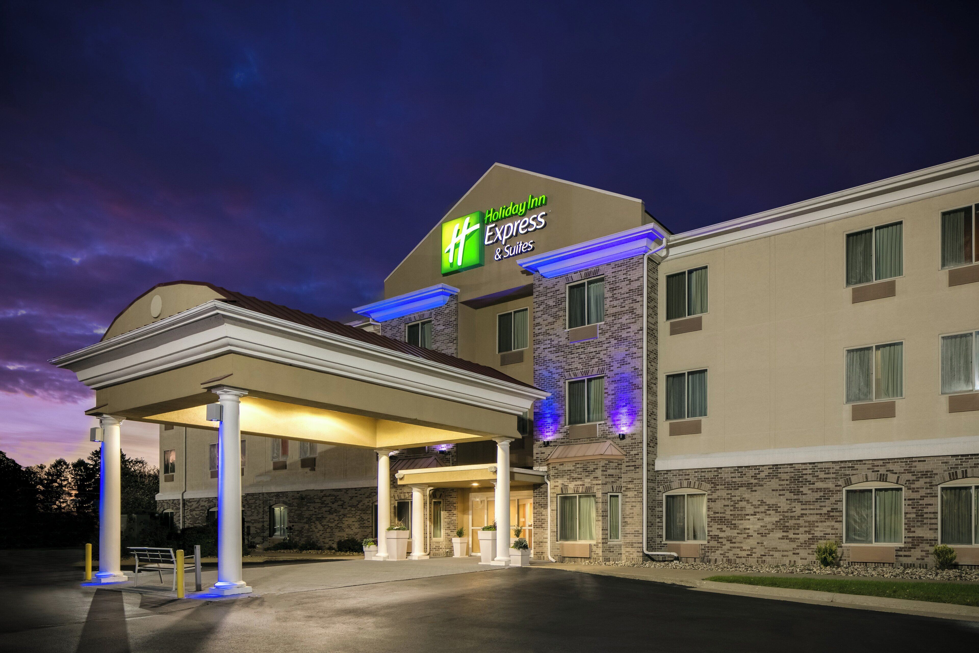 A Holiday Inn Express & Suites building with a covered entrance and multiple windows.