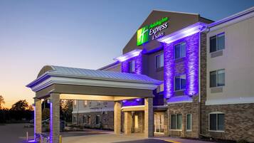 A Holiday Inn Express & Suites building with a covered entrance and a brick facade.