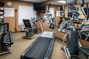 A fitness center with treadmills, elliptical machines, and free weights.
