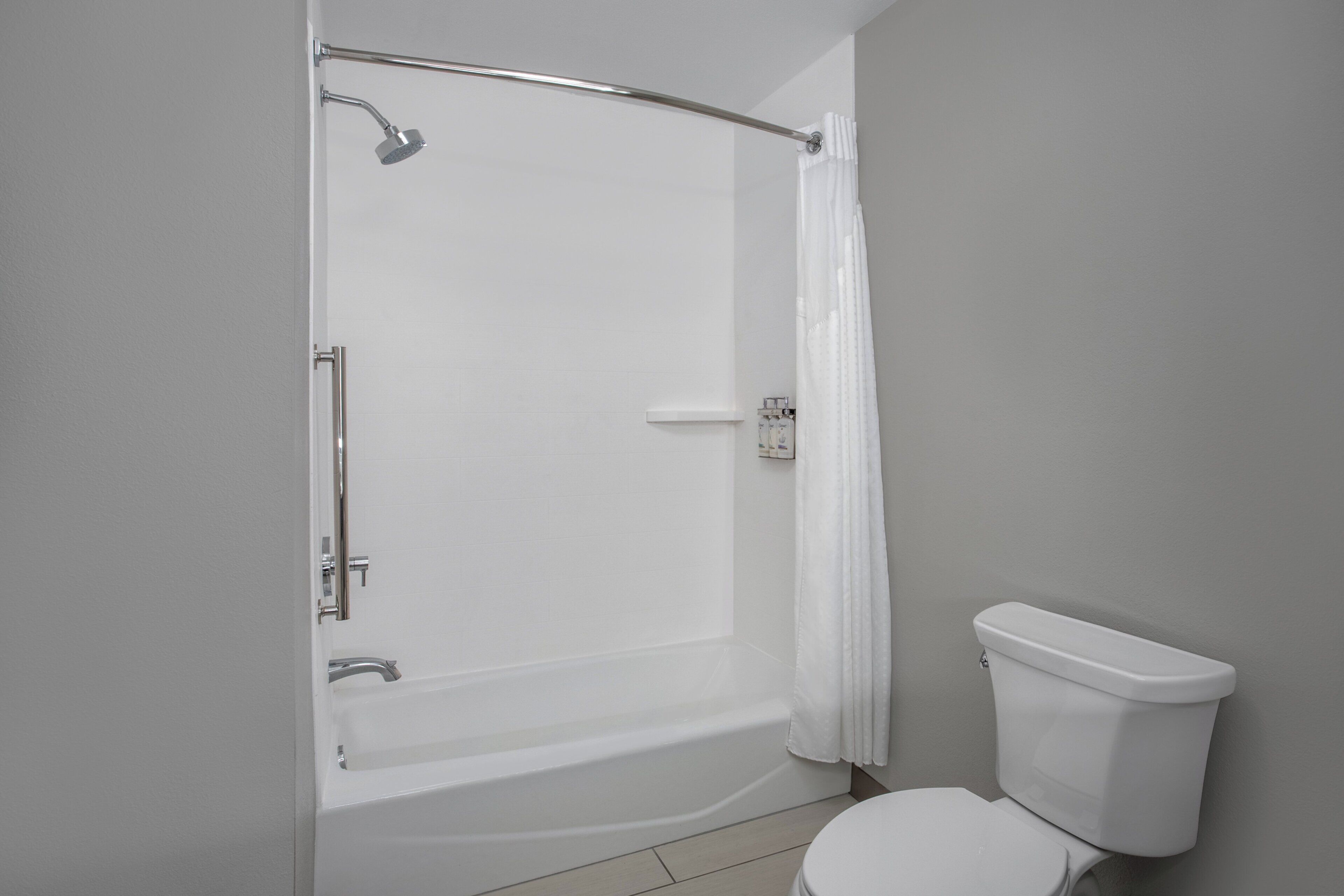 Un baño con bañera, inodoro y cortina de ducha.