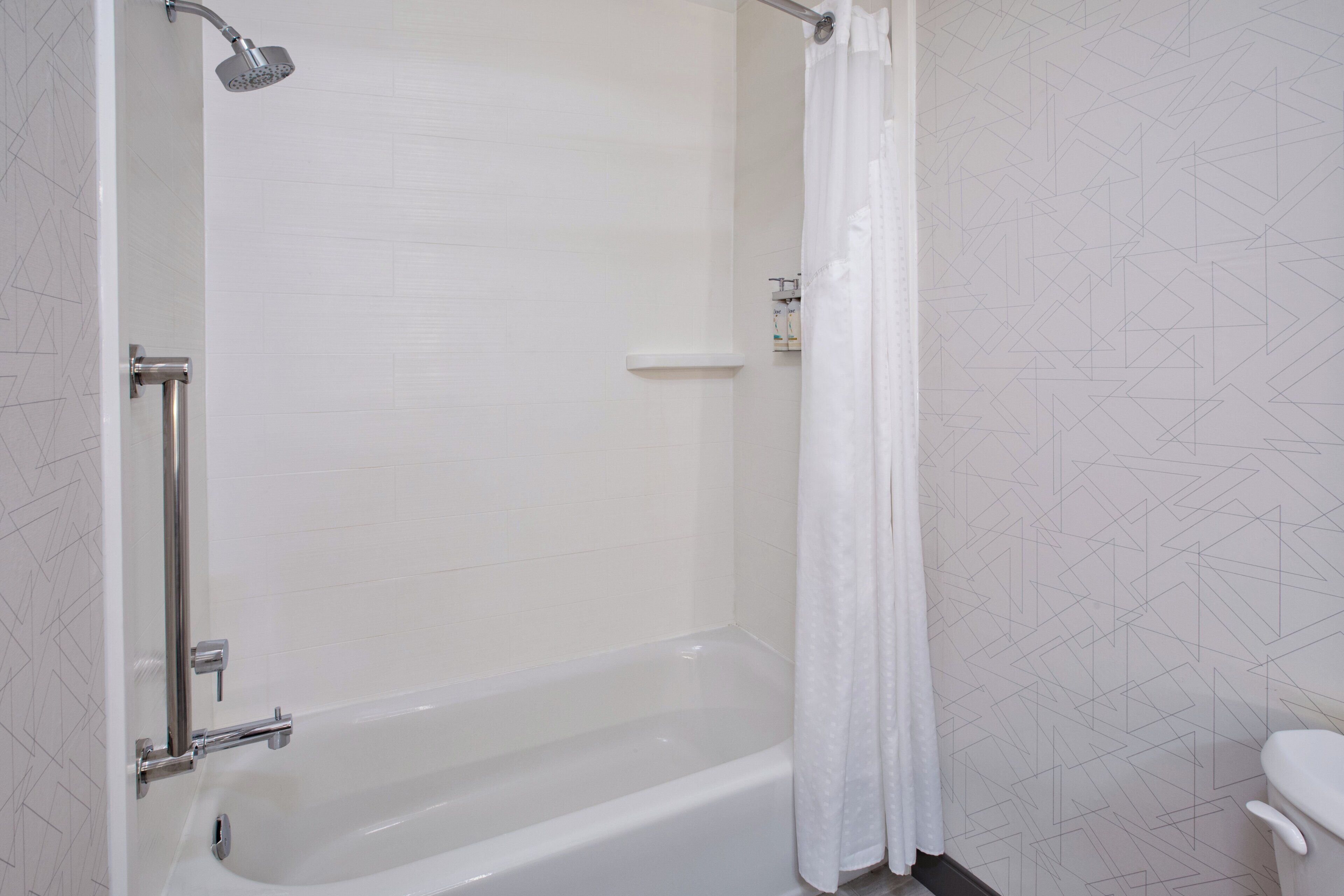 Ein Badezimmer mit Badewanne, Dusche, Toilette und Handtuchhalter.