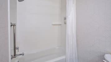 Ein Badezimmer mit Badewanne, Dusche, Toilette und Handtuchhalter.