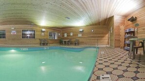 A wooden cabin with a swimming pool, a tiled floor, and a small table with chairs.