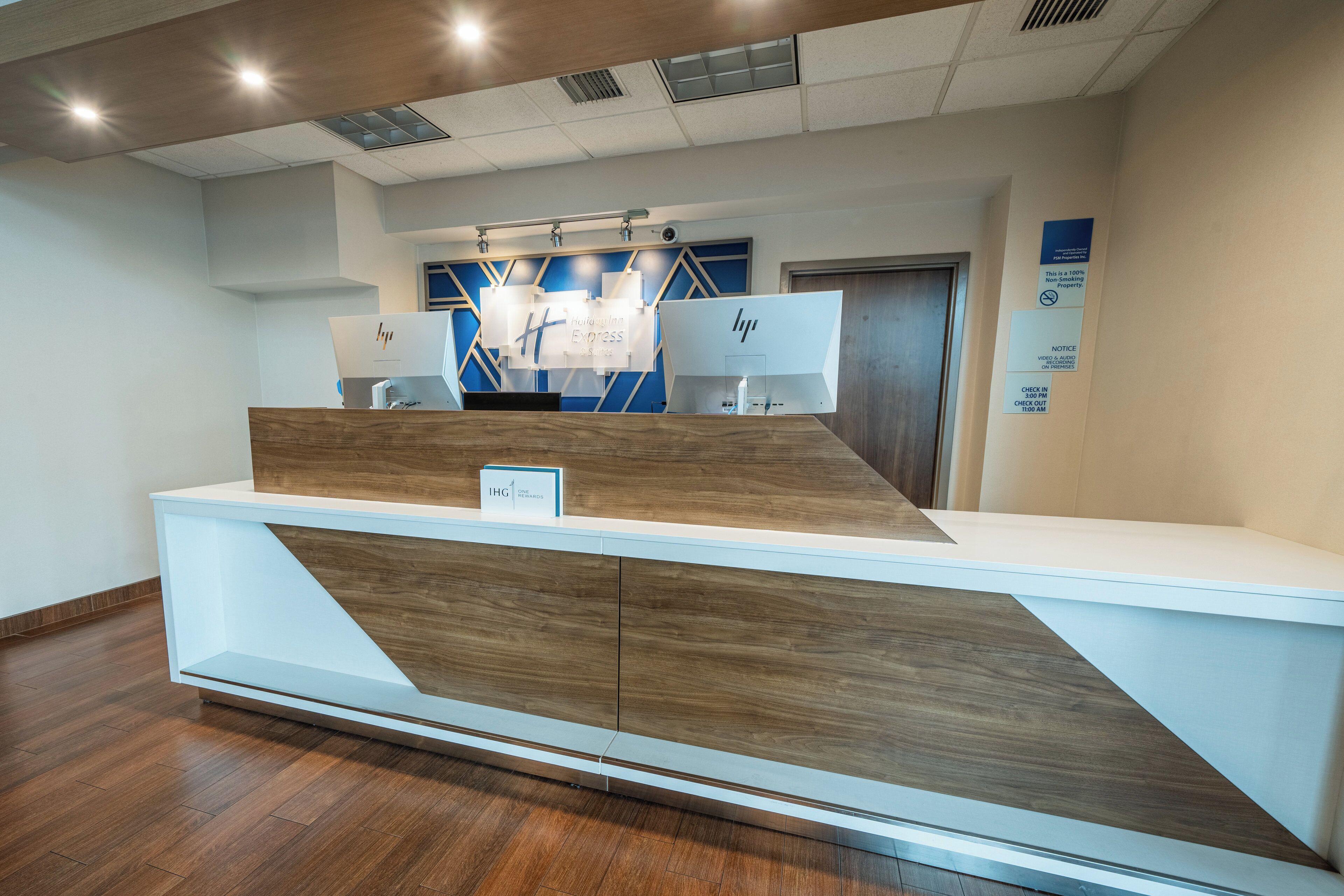 Una recepción con diseño moderno, que presenta un detalle de madera y una barra blanca.