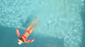 Una persona flotando en una piscina azul cristalina.