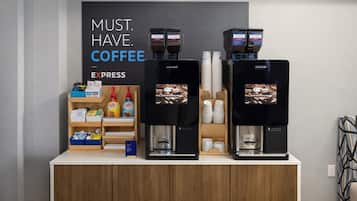 Uma estação de café com duas máquinas de expresso, um dispensador de grãos de café e diversos copos e recipientes para café.