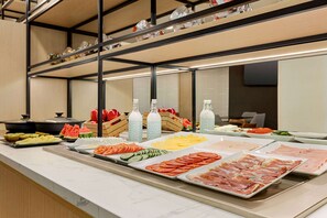 Un buffet con diverse pietanze tra cui frutta, verdura e carni.