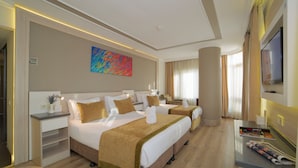 A hotel room with a large bed, a desk, a TV, and a colorful painting on the wall. - Bulvar Palas Old City Hotel (Istanbul)