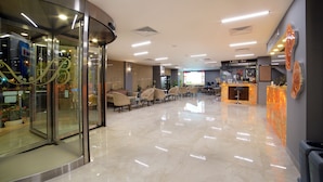 A modern lobby with a glass entrance, seating area, and a bar. - Bulvar Palas Old City Hotel (Istanbul)