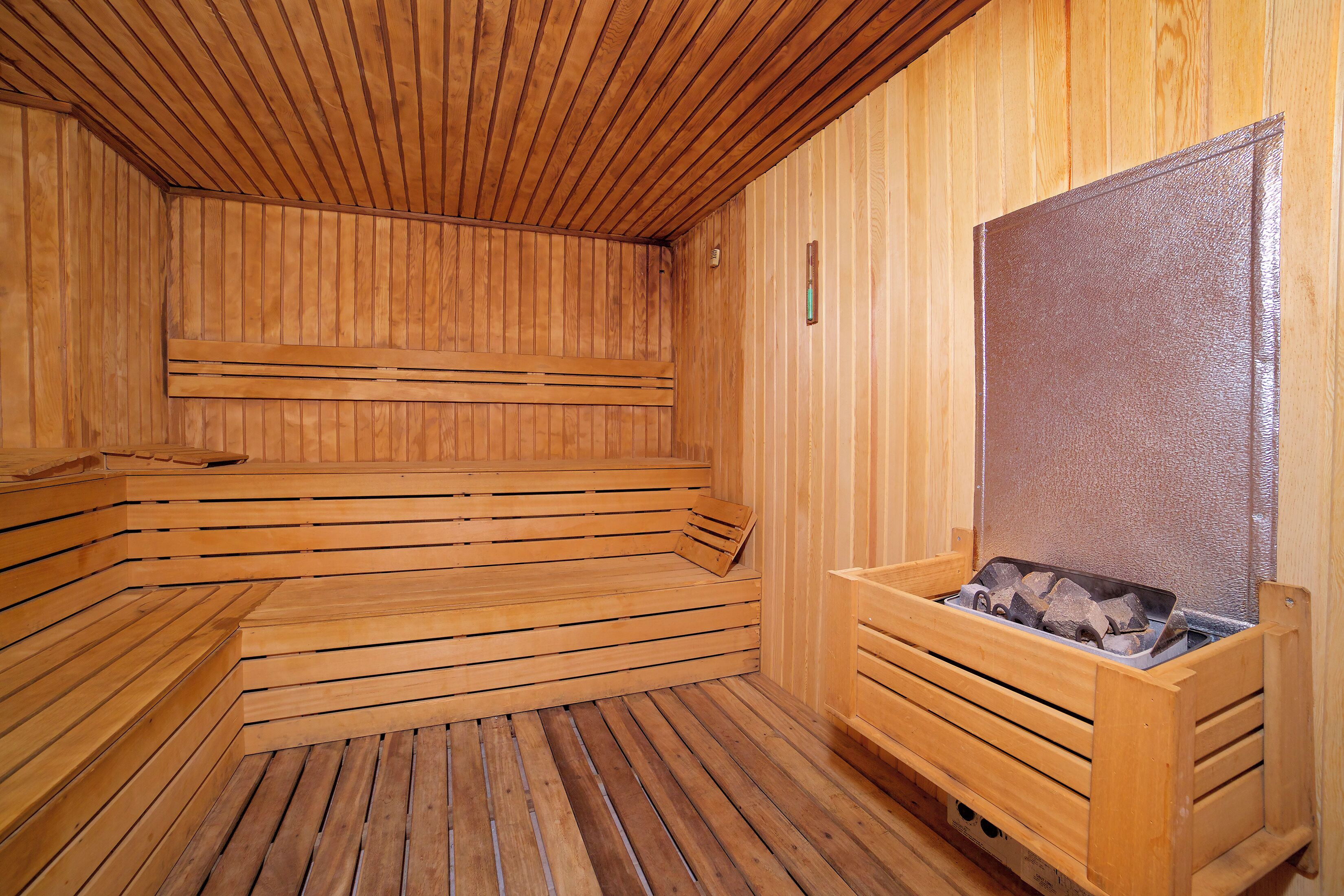 A wooden sauna with benches and a bench with a firebox.
