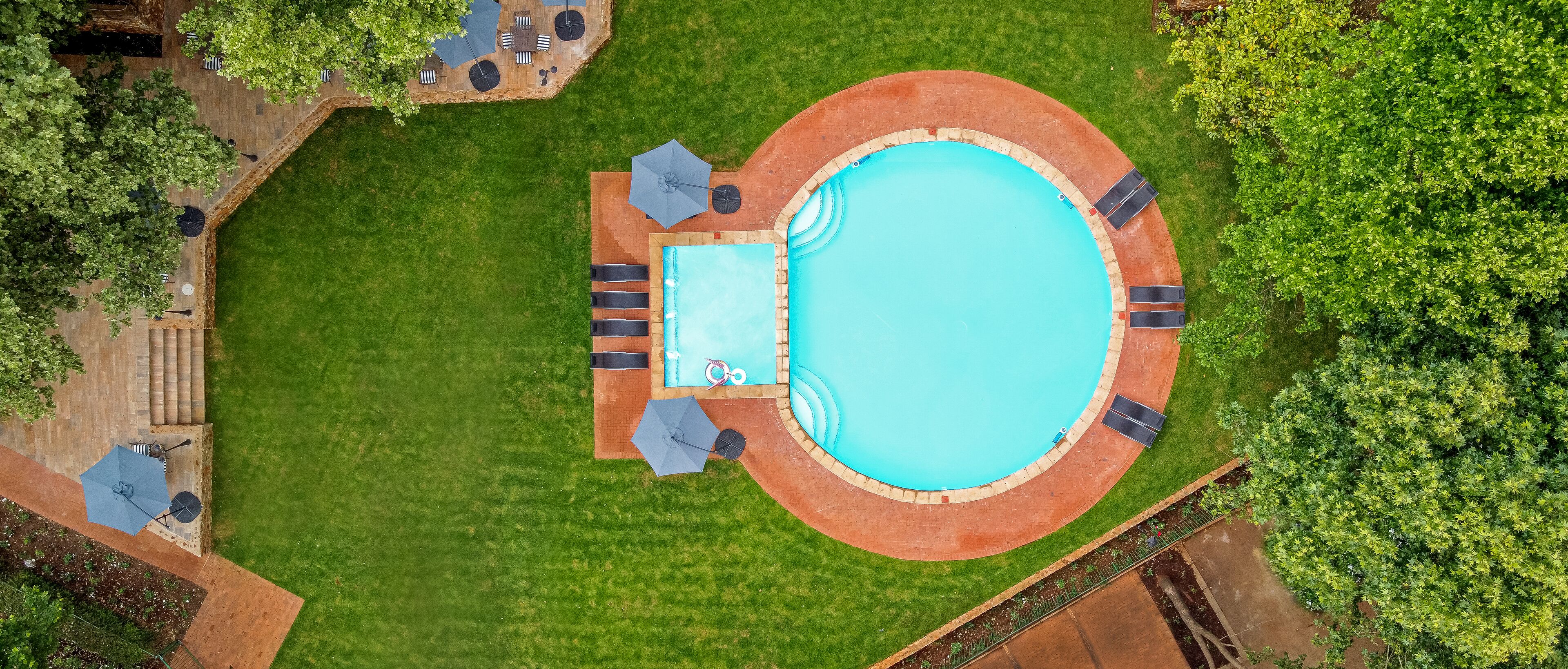 Una piscina al aire libre, sillones reclinables de piscina