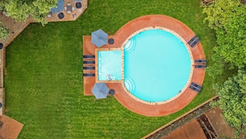 Una piscina al aire libre, sillones reclinables de piscina