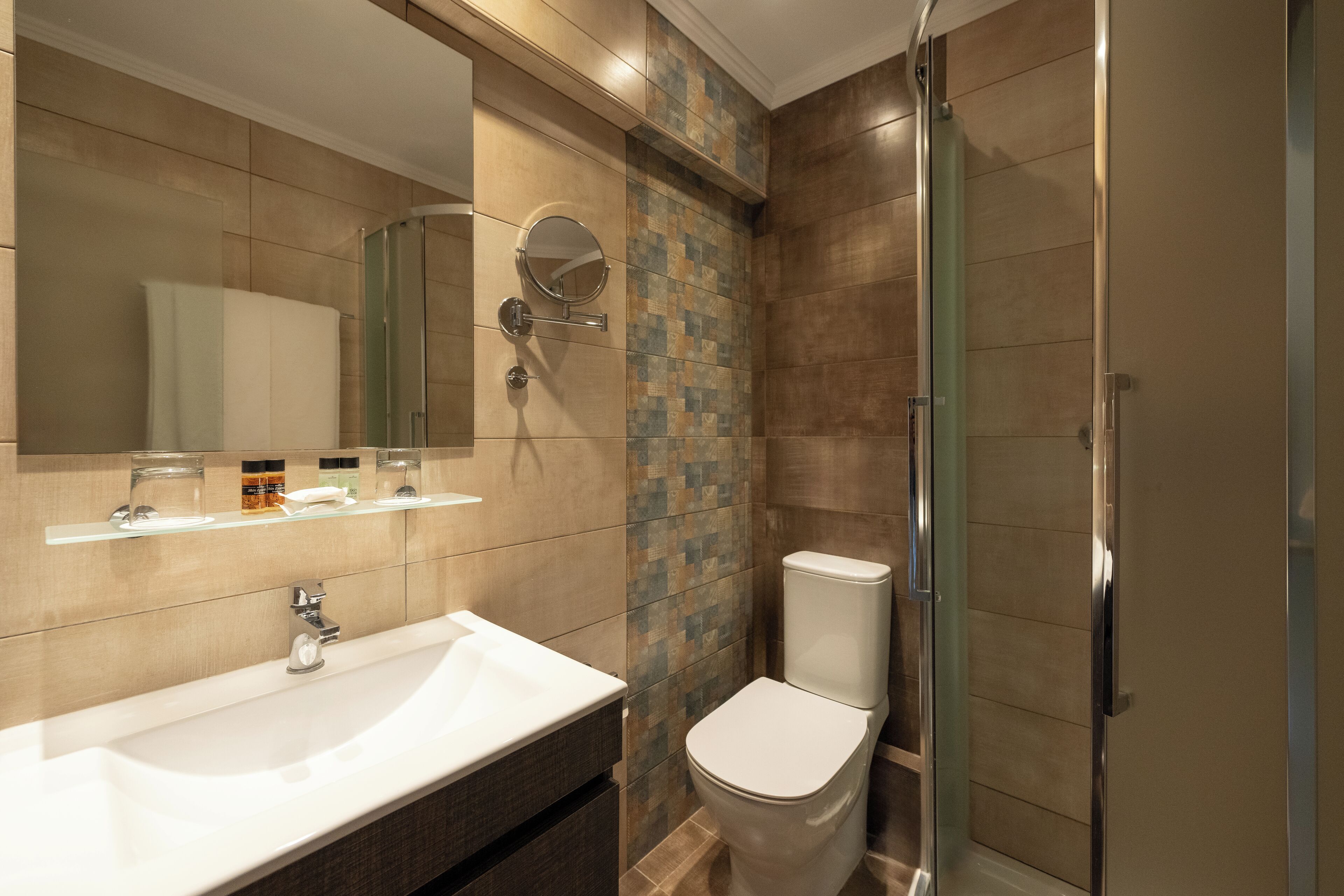 A modern bathroom with a large sink, mirror, and toilet.
