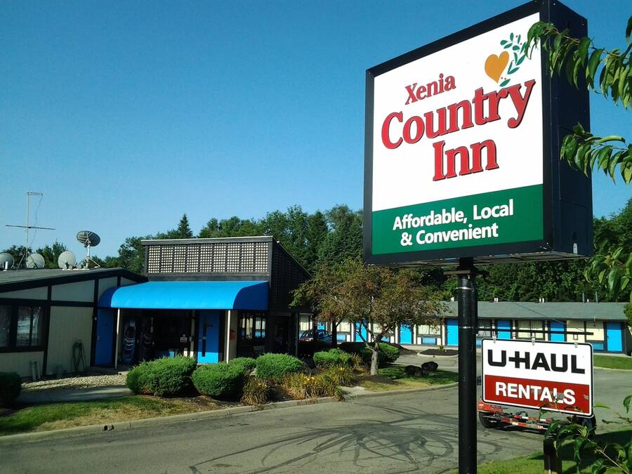 Un letrero de Xenia Country Inn con un cartel de alquiler de U-Haul cerca.