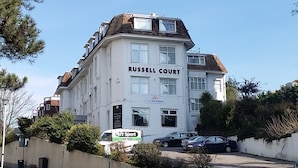 Ein mehrgeschossiges Gebäude namens 'Russell Court' mit heller Fassade und zahlreichen Fenstern.