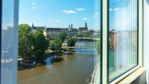 Une vue sur une rivière, avec un pont, des bâtiments et des arbres.