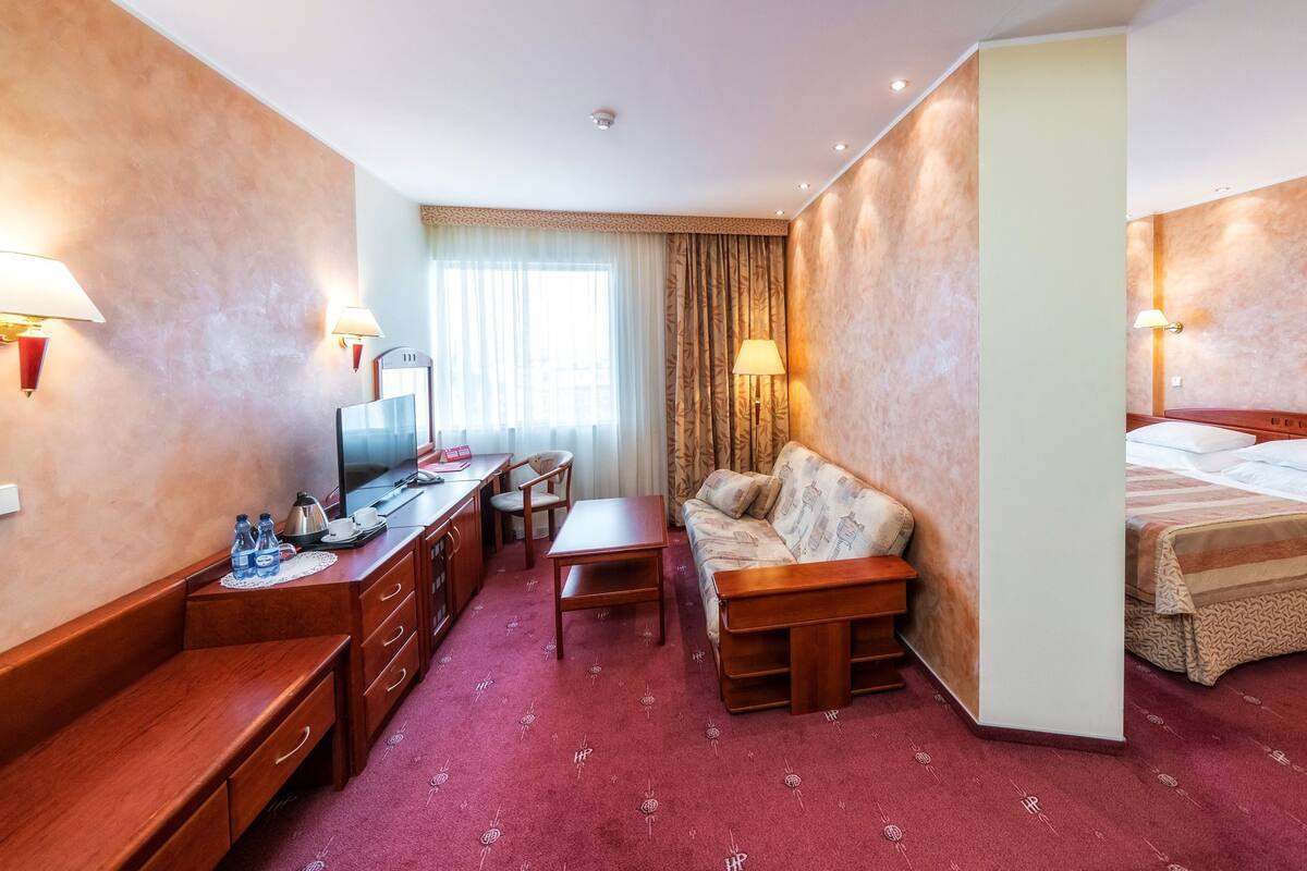 Une chambre d’hôtel équipée d’un bureau, d’une chaise, d’un canapé et d’un lit.