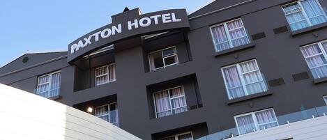 A multi-story building with a sign that reads 'Paxton Hotel.'