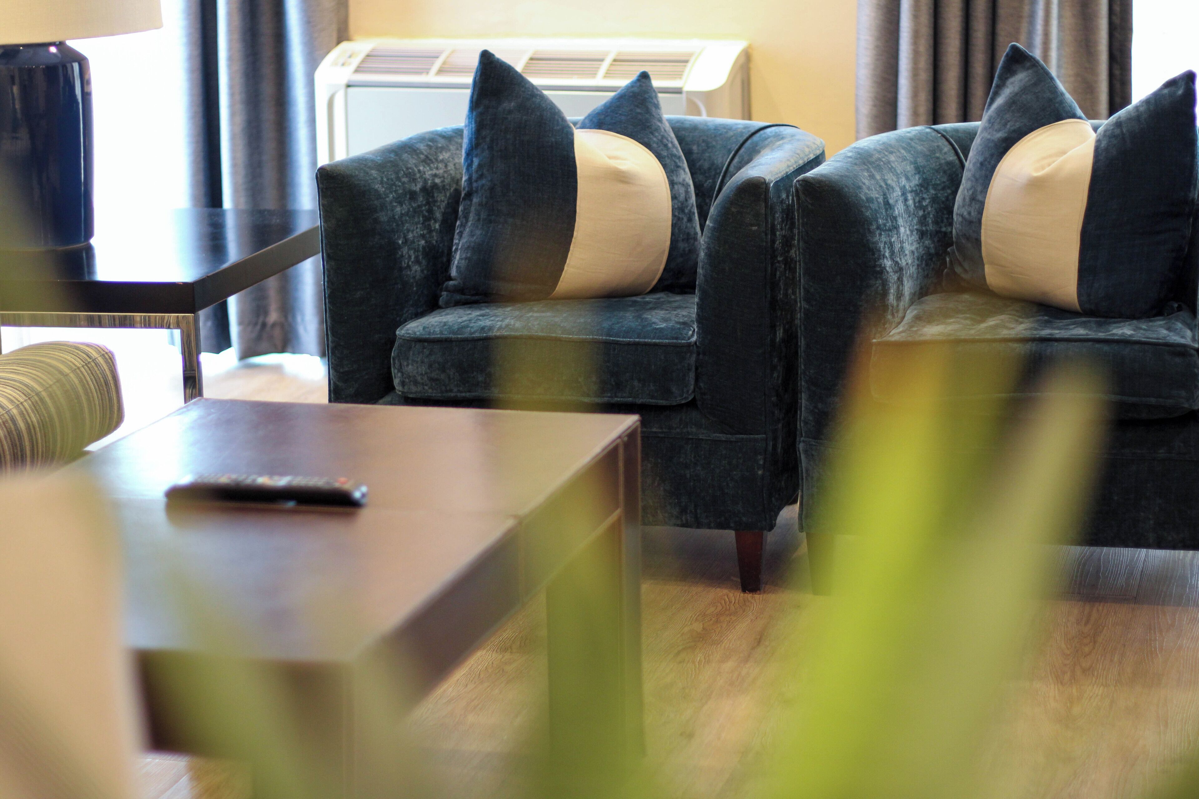 A modern living room with a sofa set, a coffee table, and a remote control on it.