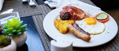 Un plato de desayuno con huevos, tocino, salchichas y tostadas.