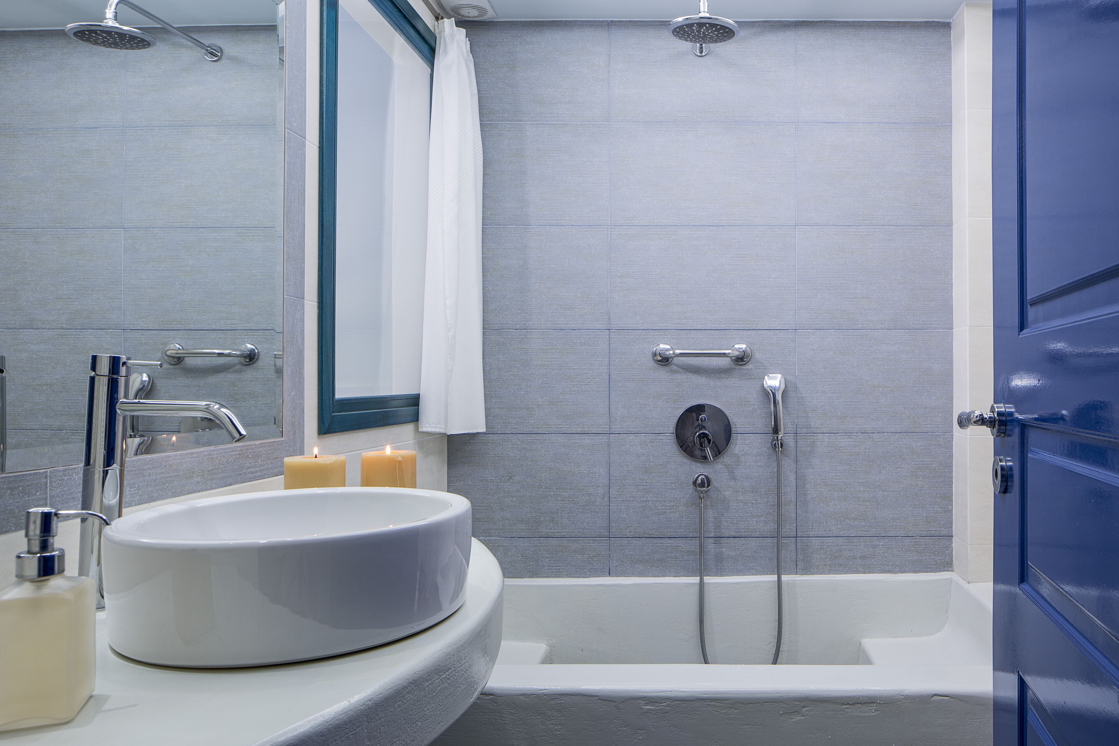 A modern bathroom with a round sink, a bathtub, and a shower.