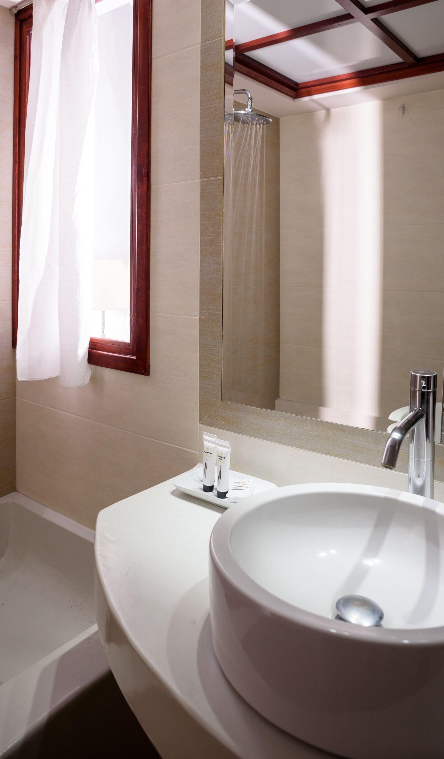 A bathroom with a white sink, a mirror, and a shower.