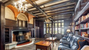 Un salon spacieux avec une cheminée, un canapé en cuir, une table basse en bois et des étagères.