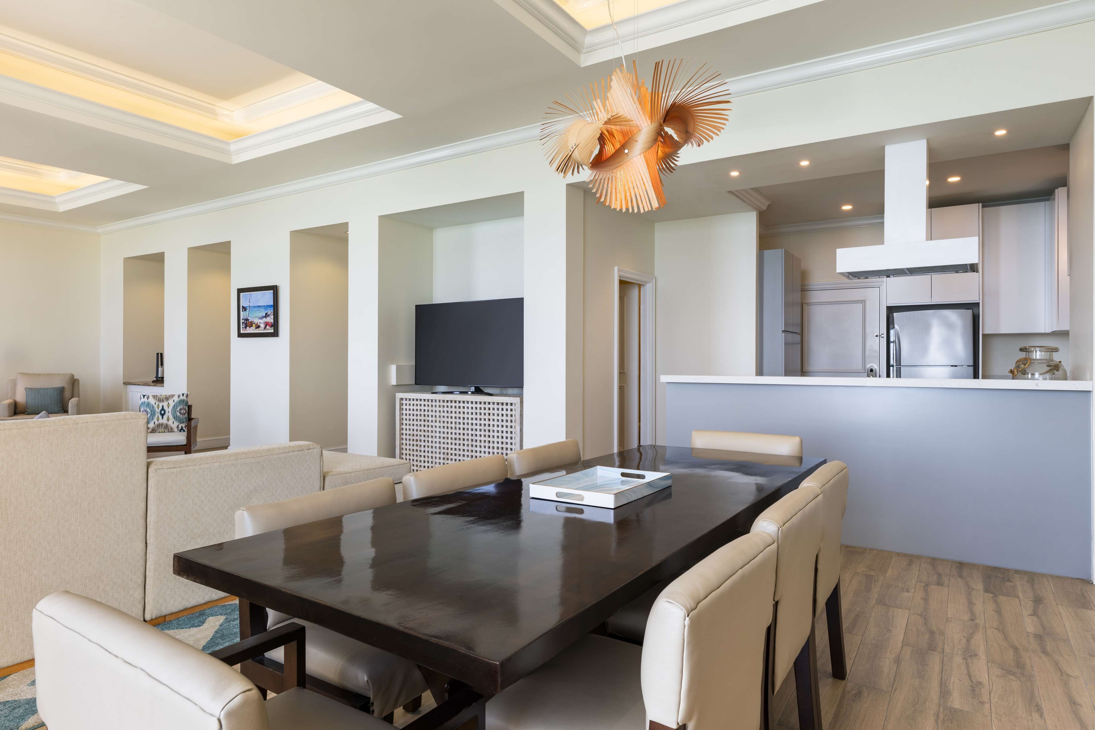 Quarto de hotel moderno com área de refeições, cozinha e sala de estar.
