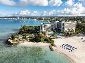 A resort with a beachfront, swimming pool, and multiple hotel buildings. - Hilton Barbados Resort (Bridgetown)