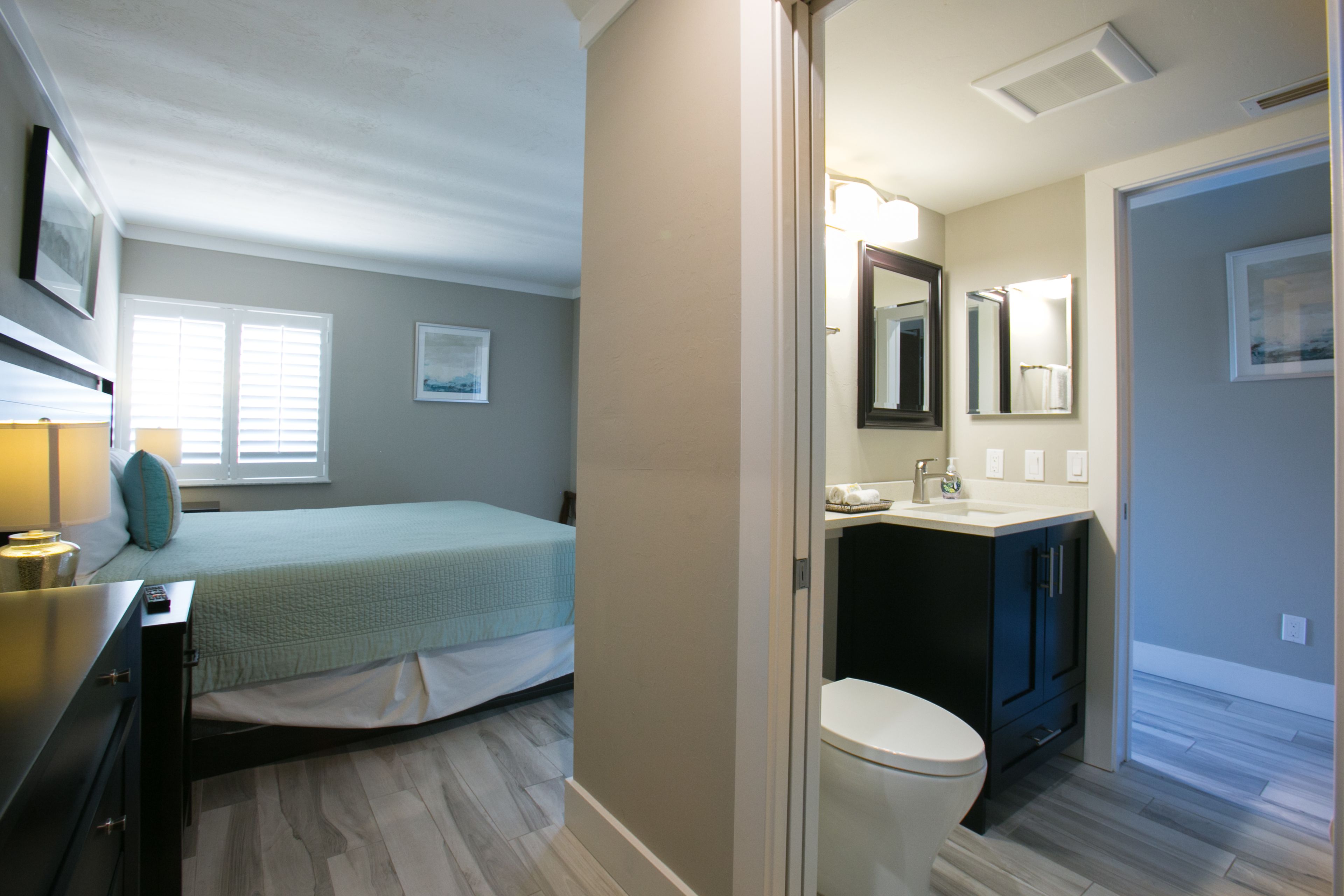 A bedroom with a bed, bedside table, and a window.