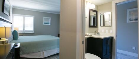 A bedroom with a bed, bedside table, and a window.