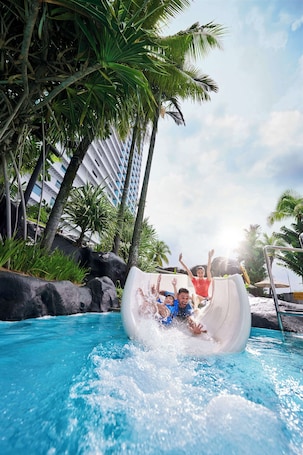 Una piscina al aire libre, tumbonas. Hilton Kuala Lumpur