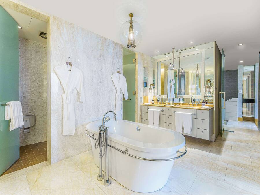 A modern bathroom with a freestanding bathtub, a large mirror, and a glass-enclosed shower area.