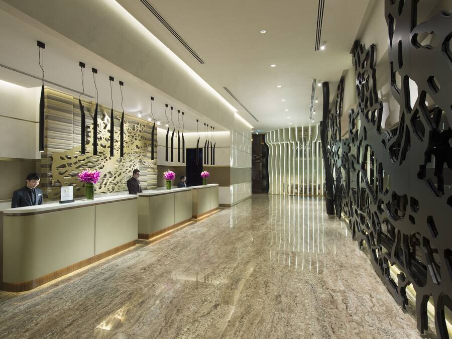 A modern reception area with a marble floor, a reception desk, and decorative wall panels.