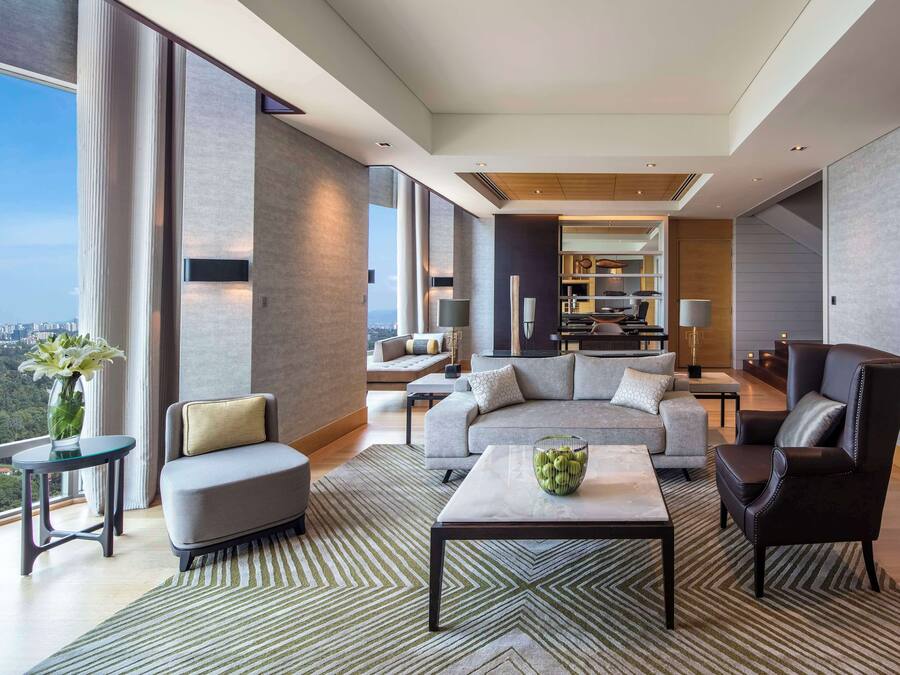Un salón espacioso con un sofá moderno, una mesa de centro y vistas a la ciudad.