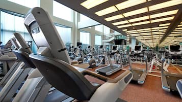 Una palestra con tapis roulant, cyclette e macchinari per l'allenamento con i pesi.