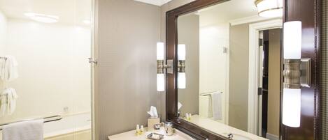 Une salle de bain moderne avec un grand miroir, un lavabo et une douche à parois de verre.