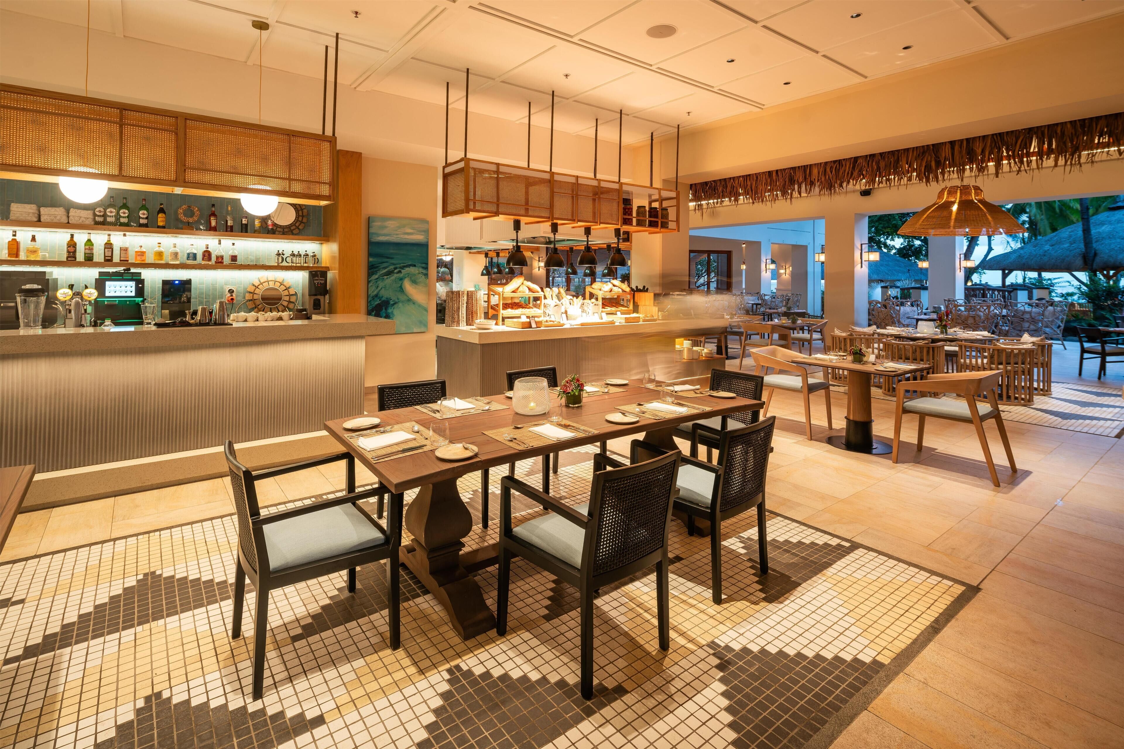 A restaurant with a bar area, multiple dining tables, and chairs.