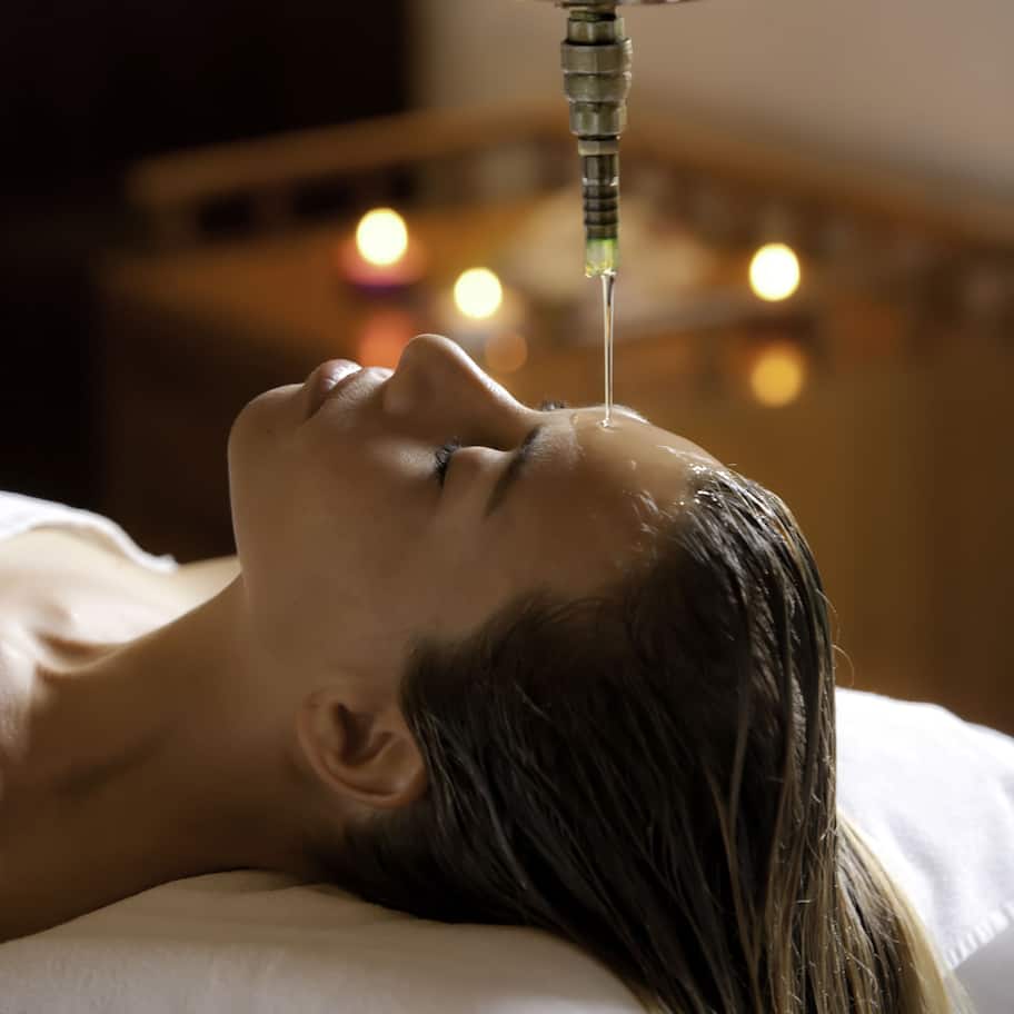 A person lying down with a metal device above their head, possibly for a medical procedure.