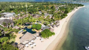 Ein Resort mit Strand, Schwimmbad und Bergblick.