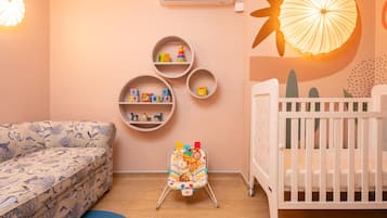 A baby room with a crib, a changing table, and a sofa.