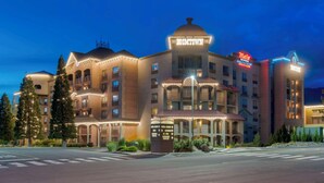 A hotel with multiple floors, a prominent dome-shaped structure, and a neon sign for a restaurant.