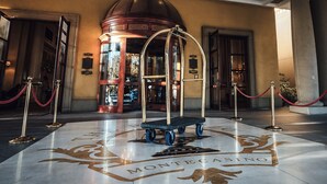 A grand entrance with a marble floor, a central blue bench, and a red rope barrier. - Palazzo Hotel (Sandton)
