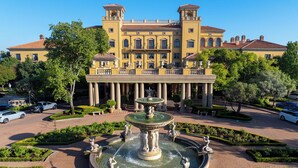 A large building with a central courtyard, a fountain, and a statue. - Palazzo Hotel (Sandton)