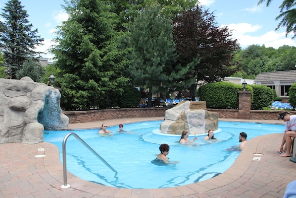 Una piscina techada, una piscina al aire libre de temporada, sombrillas