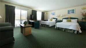 A hotel room with two beds, a desk, a chair, and a television.