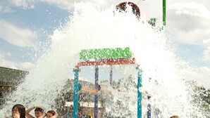 Parque aquático com estrutura de recreação aquática e pessoas se divertindo na água.