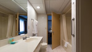A bathroom with a large sink, toilet, and shower area.